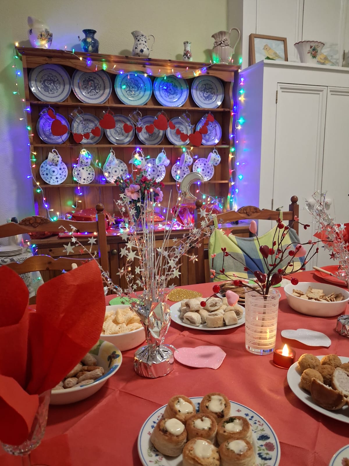 A celebration table with food, decorations and colourful lights at Treveor House