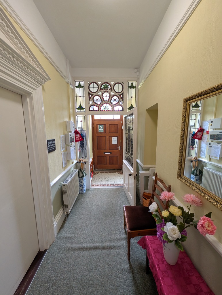 Treveor House entrance hall with its original stained-glass doorway